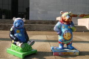 Two bears in front of air and space musuem; one with solar system and other as astronaut
