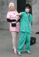 nurse in pink; doctor in green scrubs