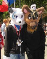 Two men wearing white and brown fox/wolf-like full head masks