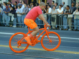 Man dressed in orange on orange bicycle