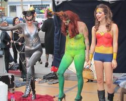 Women body-painted as Catwoman, Poison Ivy, and Wonder Woman
