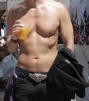 Torso of shirtless guy holding jacket in one hand and beer in the other.