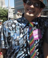 man in sunglasses wearing a rainbow-colored tie made of beads