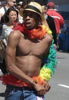 African-american shirtless guy with rainbow feather boa and straw fedora