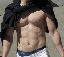 shirtless caucasian with black sweater tied loosely around his neck.